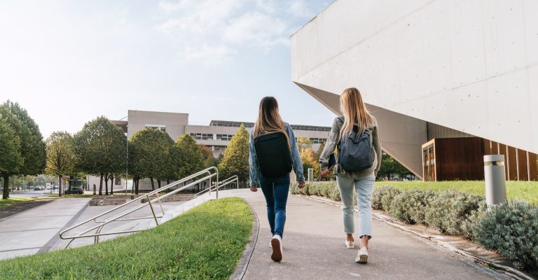 Two people walking on a college campus